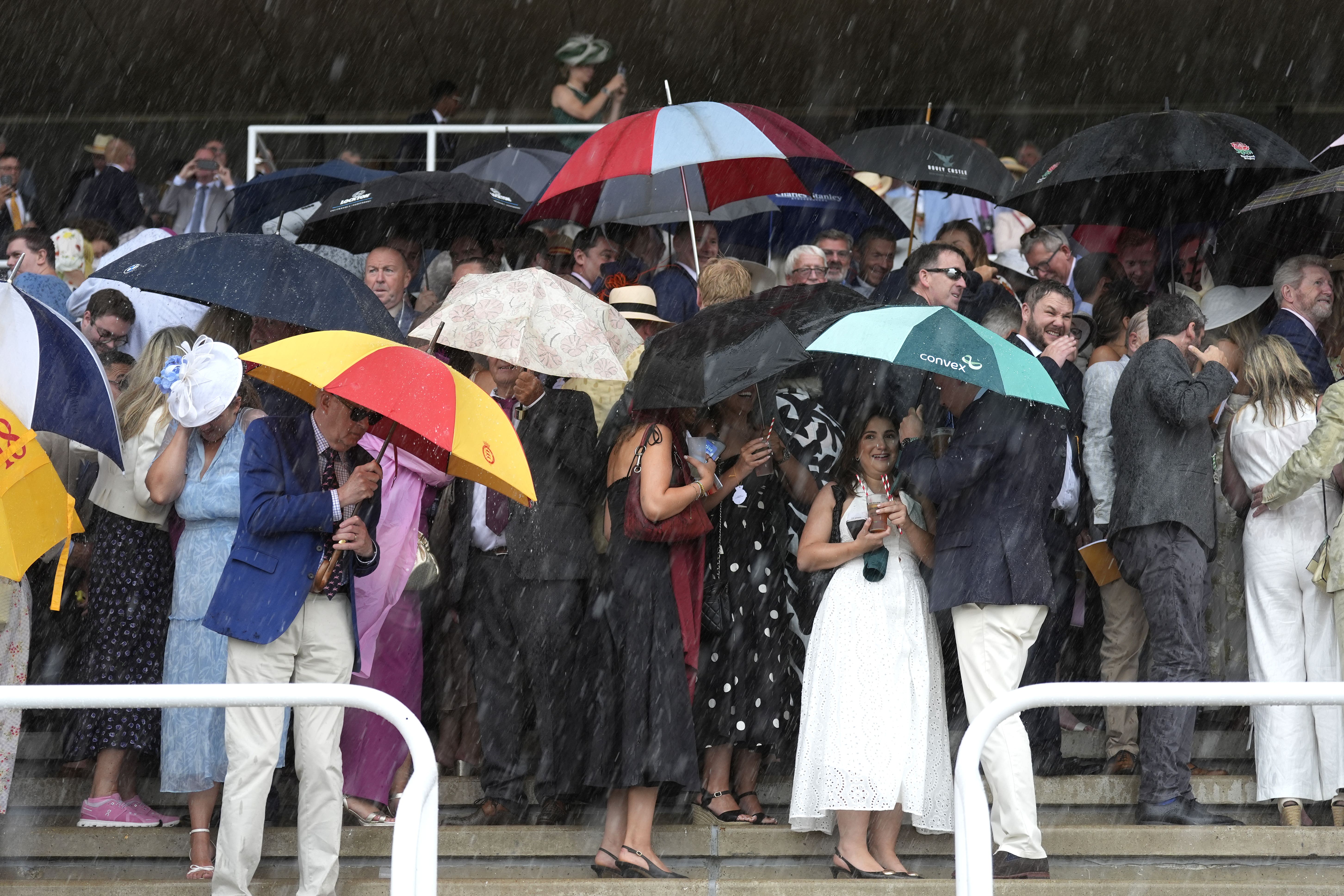 Racegoers ducking for cover at Goodwood